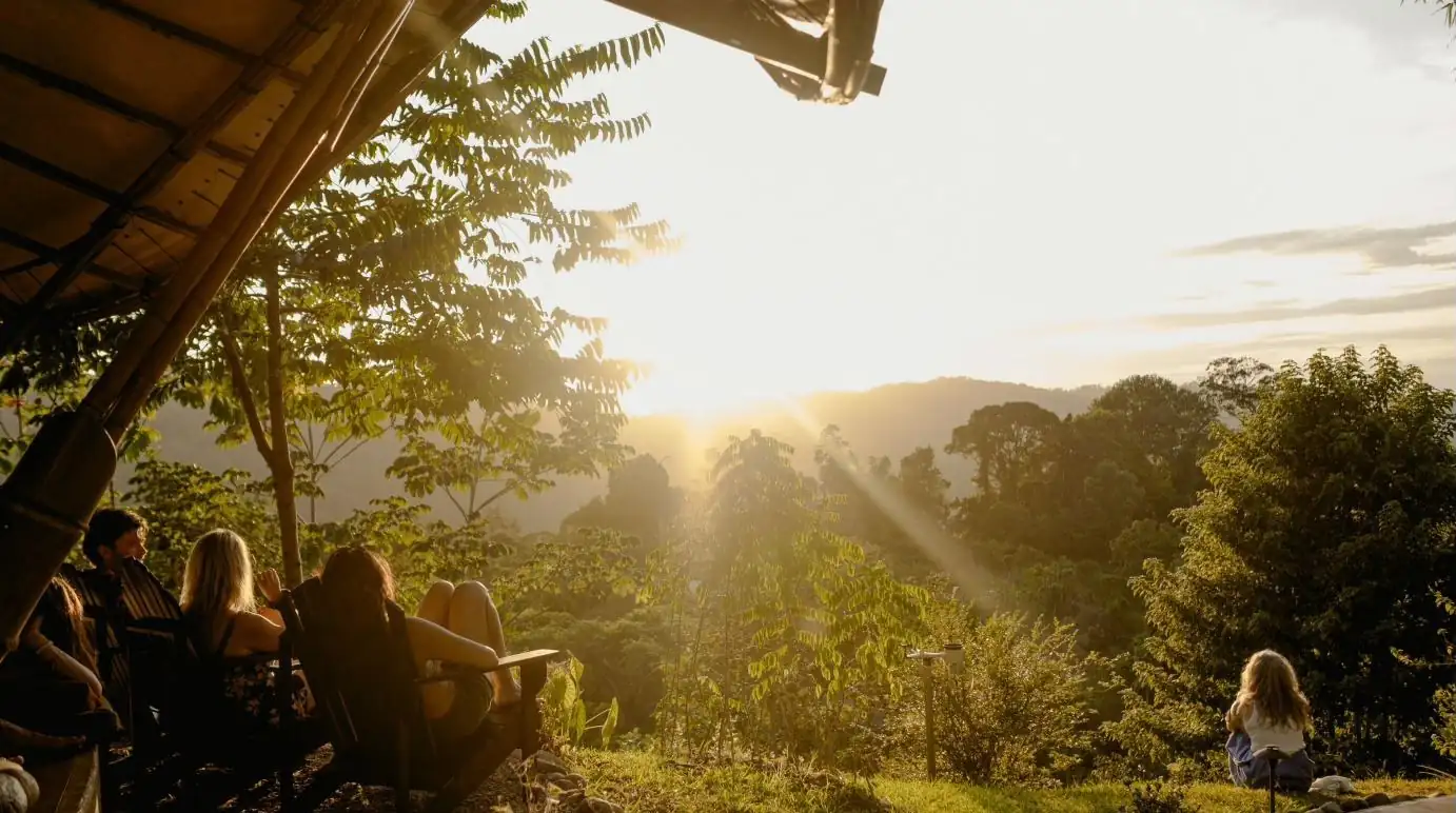 Guests gathered under the open-air temple at dusk, looking out over the valley as the sun sets